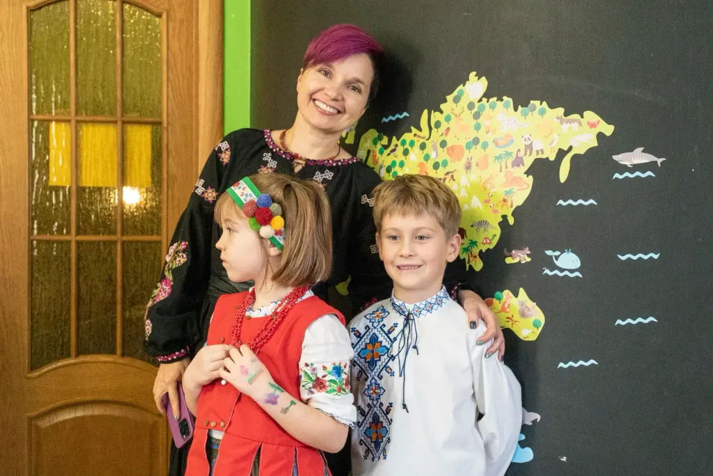 Yana Moskovchenko with ThinkGlobal elementary students in traditional Ukrainian attire during a "Vechornytsi" school event