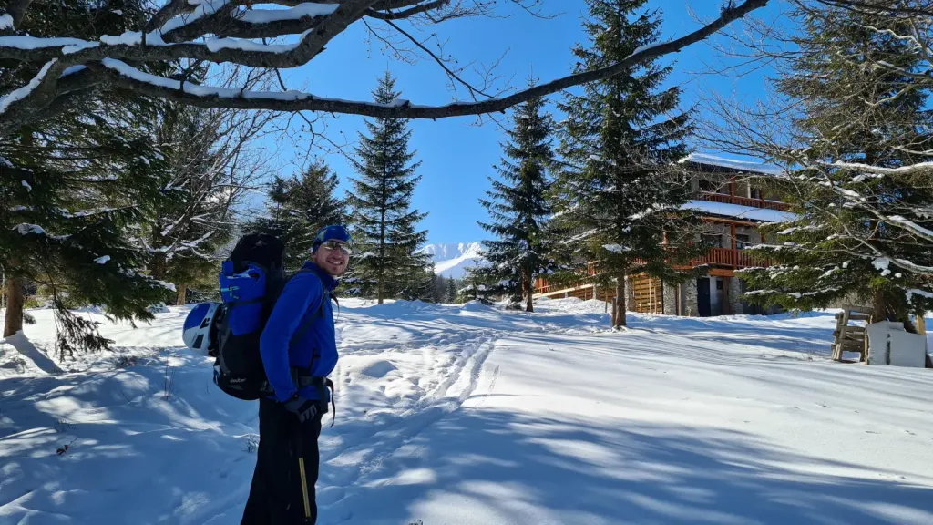 Head of Marketing Ture Roman Kozachuk on a winter hike with a mountain and cottage background
